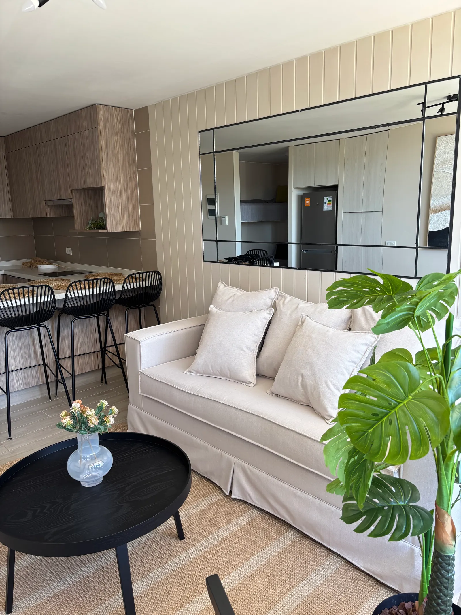 Foto real del living terminado y decorado, con la cocina al fondo