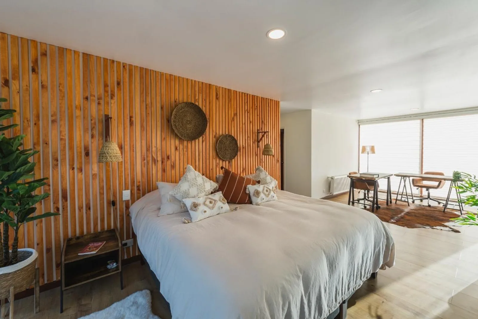 Dormitorio con revestimiento de madera y decoración boho